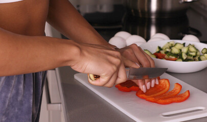 Human hands cooking vegetables salad in kitchen.