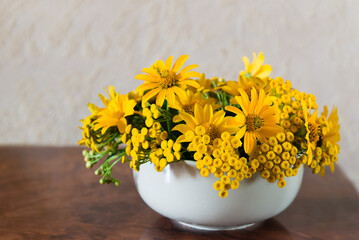 Bouquet of bright different yellow flowers on a table	