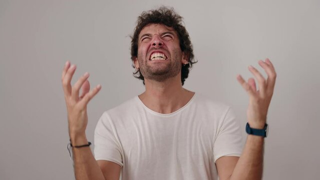 Young hispanic man standing with furious expression over isolated white background