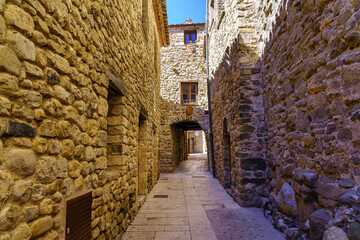 Fototapeta na wymiar Picturesque narrow alley with houses built entirely of stone in the medieval town of Besalu, Girona.