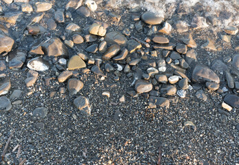 Kieselsteine am Strand mit Wasser