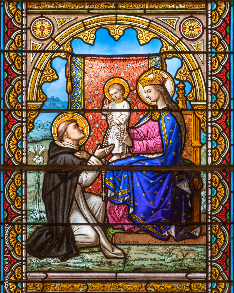 Wall mural ALAGNA, ITALY - JULY 16, 2022: The Madonna presenting the Rosary to st. Dominic on the stained glass in the church San Giovanni Battista by J. Besnard (1890).