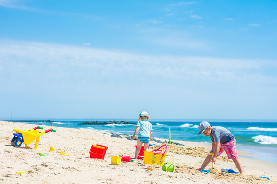 Brother and sister are building a sand castle on the sea shore