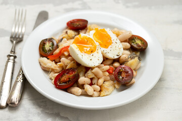 Salad with Fried cod fish and white beans on the plate on ceramic.