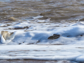 The texture of water with sea foam and waves. Natural water background