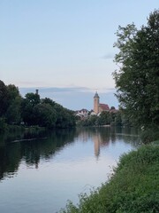 Obraz premium Die Stadtkirche St. Laurentius spiegelt sich im Abendlicht im Neckar in Nürtingen.