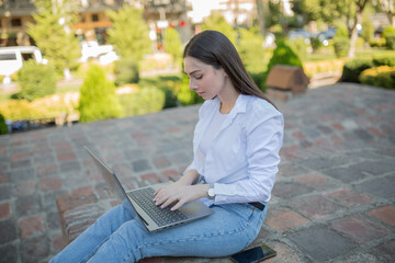 Beautiful woman with a laptop. sitting in the park