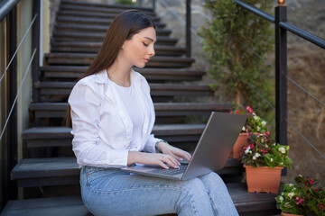Beautiful woman with a laptop. Sitting on the open summer terrace