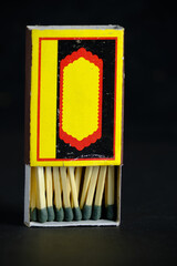 Open and full matchbox on black background.