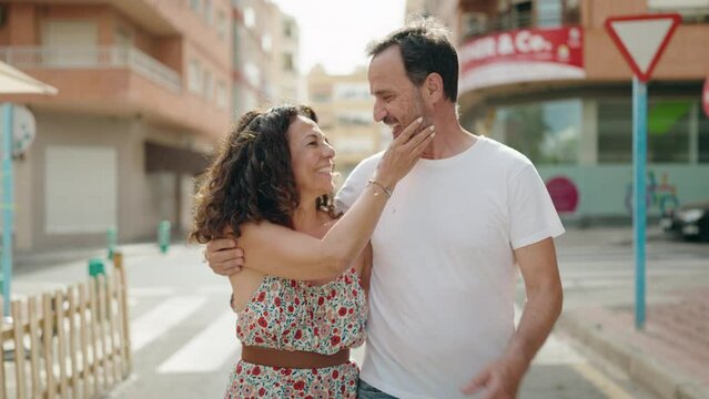 Man and woman couple hugging each other walking at street