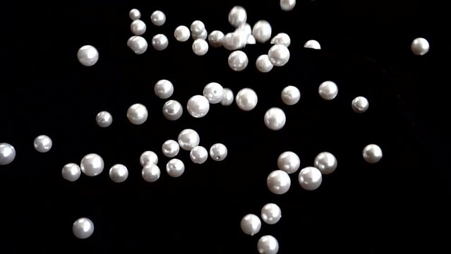 White pearls fall. Slow motion.