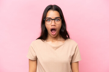 Young Colombian woman isolated on pink background With glasses and surprised expression