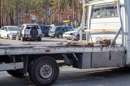 Lots of old cars ready for recycling. Car removal by tow truck. The car is getting ready to be loaded onto a tow truck. Old wrecked cars in a junkyard are waiting to be destroyed in a recycling park.