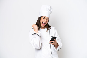 Young Brazilian chef woman isolated on white background with phone in victory position