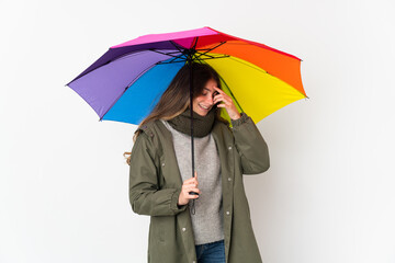 Young caucasian woman holding an umbrella isolated on white background laughing