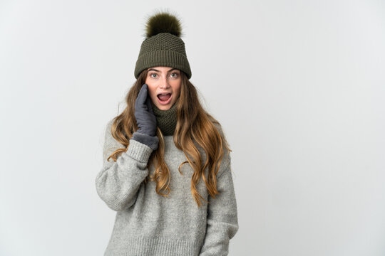 Young caucasian woman with winter hat isolated on white background with surprise and shocked facial expression