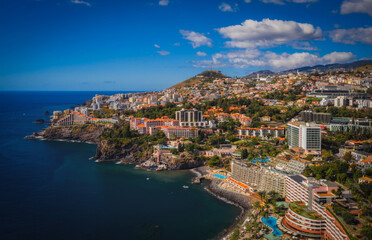 Fototapeta na wymiar Scenery around Funchal, a city of the portuguese island named Madeira. View on harbour from the ocean. Aerial drone shot. October 2021