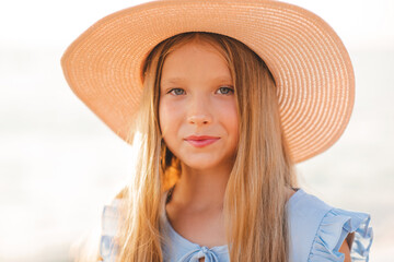 Smiling blonde teenage girl 12-14 year old wear straw hat over sun light outdoor. Look at camera....