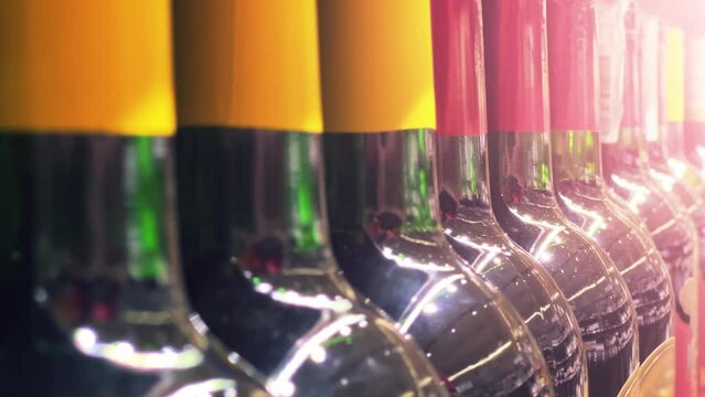 Red wine bottles line up on the shelf of a liquor store (ABC store) or supermarket. Close up shot