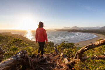 Adventurous Woman Hiker overlooking Sandy Beach on the West Coast of Pacific Ocean. Canadian Nature Landscape Background. Cox Bay Lookout, Tofino, Vancouver Island, BC, Canada. © edb3_16