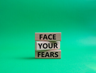 Face your Fears symbol. Wooden blocks with words Face your Fears. Beautiful green background. Business and Face your Fears. Copy space.