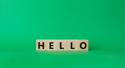 Hello symbol. Wooden cubes with word Hello. Beautiful green background. Hello concept. Copy space.