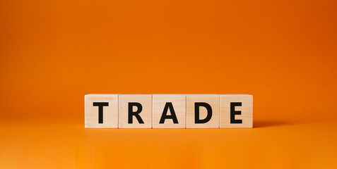 Trade symbol. Wooden cubes with word Trade. Beautiful orange background. Trade concept. Copy space.