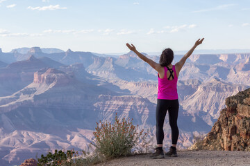 Fototapeta na wymiar Adventurous Traveler standing on Desert Rocky Mountain American Landscape. Cloudy Sunny Sky. Grand Canyon National Park, Arizona, United States. Adventure Travel