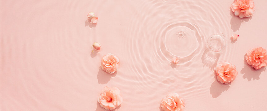 Pink aquatic, transparent water texture with ripples and drops and pink flowers