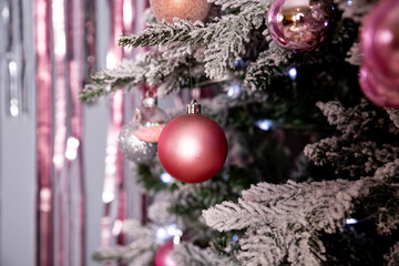 Christmas holiday, fir branches, conifer cones, silver,pink ornaments.Decorated Christmas tree.Glittering ball for new year.Christmas tree decorated with toys,ribbons and lights glowing garland.