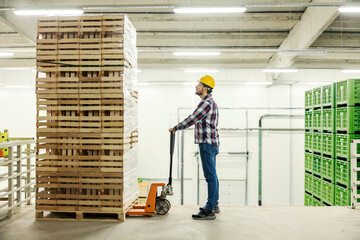 A warehouse worker using forklift for driving pallets.