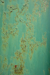 Background of metal surface with rusty cracks in its old green paint