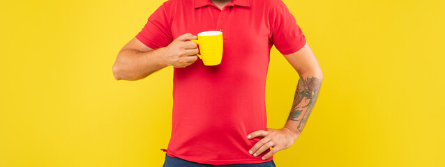 Man crop view holding mug keeping arm akimbo yellow background, tea
