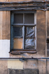 Dirty dusty window on the facade of an old house