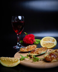 baked mussels on a round wooden board side view on a dark background