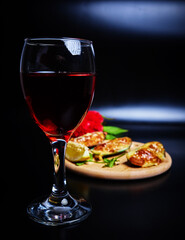 baked mussels on a round wooden board side view on a dark background