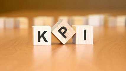 kpi text on wooden blocks, financial business concept, brown background