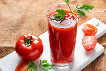 Dietary tomato juice on linen background. Healthy drink made from farm vegetables.