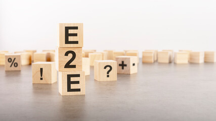 e2e text as a symbol on cube wooden blocks. many wooden blocks with symbol in the background