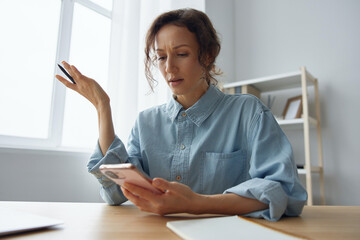 What is wrong concept. Confused upset unhappy beautiful curly lady shocked by phone gadget...