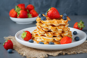 Viennese waffles, with berries, on a grey table