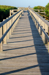 Fototapeta premium Wooden boardwalk on a beach at sunrise