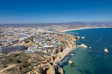 Fototapeta premium Ponta da Piedade with over rocks near Lagos in Algarve, Portugal. Ponta da Piedade, Algarve region, Portugal. Beach Tourists Umbrellas