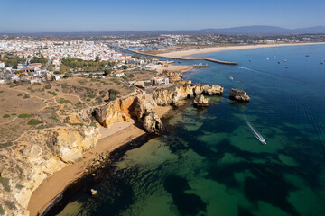 Ponta da Piedade with over rocks near Lagos in Algarve, Portugal. Ponta da Piedade, Algarve region, Portugal. Beach Tourists Umbrellas