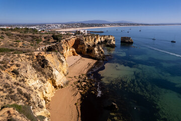 Obraz premium Ponta da Piedade with over rocks near Lagos in Algarve, Portugal. Ponta da Piedade, Algarve region, Portugal. Beach Tourists Umbrellas