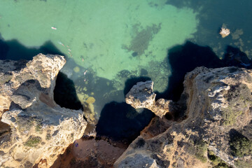 Ponta da Piedade with over rocks near Lagos in Algarve, Portugal. Ponta da Piedade, Algarve region, Portugal. Beach Tourists Umbrellas