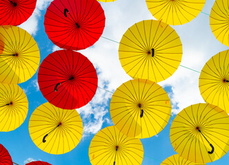 Fototapeta na wymiar Bright color umbrellas hanging bottom-up sky background
