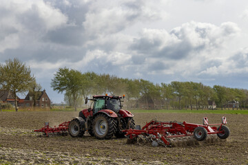 Fototapeta premium Tractor during spring work on the field