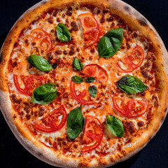 Delicious fragrant pizza with mozzarella, tomatoes and basil with tomato sauce - Margherita. Top view