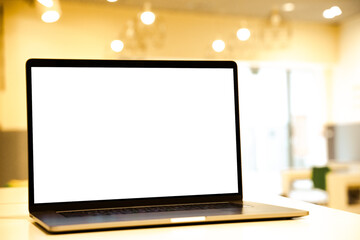 Laptop with white screen in business office or shopping mall. Empty copy space, blank screen mockup. Soft focus laptop with interor background. Travel, study and office work concept